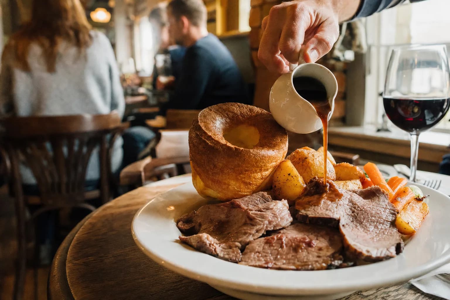 Gravy poured over a Sunday roast with a tall Yorkshire pudding (AI example photo)